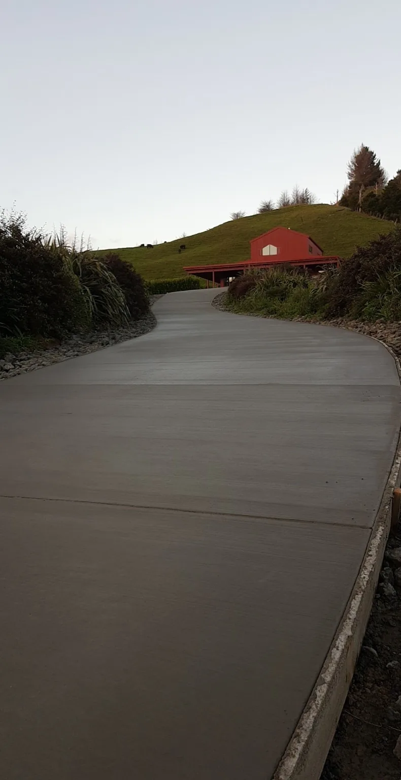 Concrete driveway curving up to a rural shed, broom finished