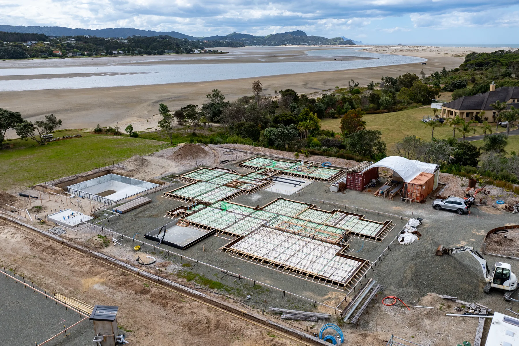 Aerial view of a reinforced ribraft slab foundation prepared by Artizen Construction at a coastal New Zealand site
