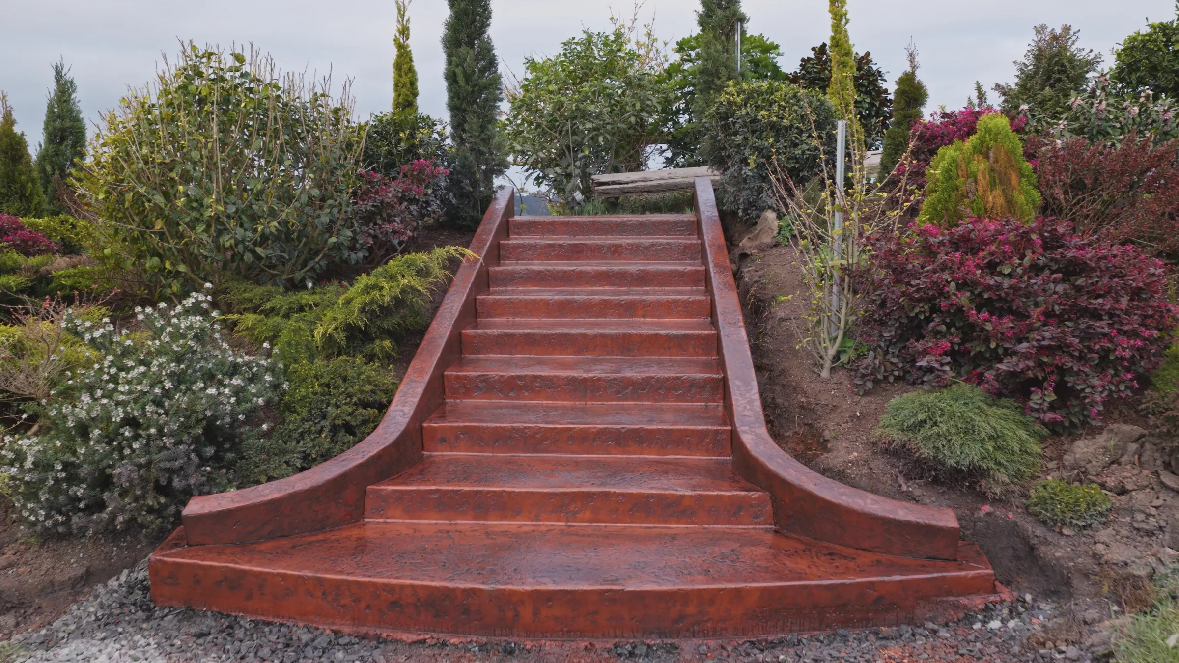 Sculptural terracotta concrete staircase with flared curved base, Matakana
