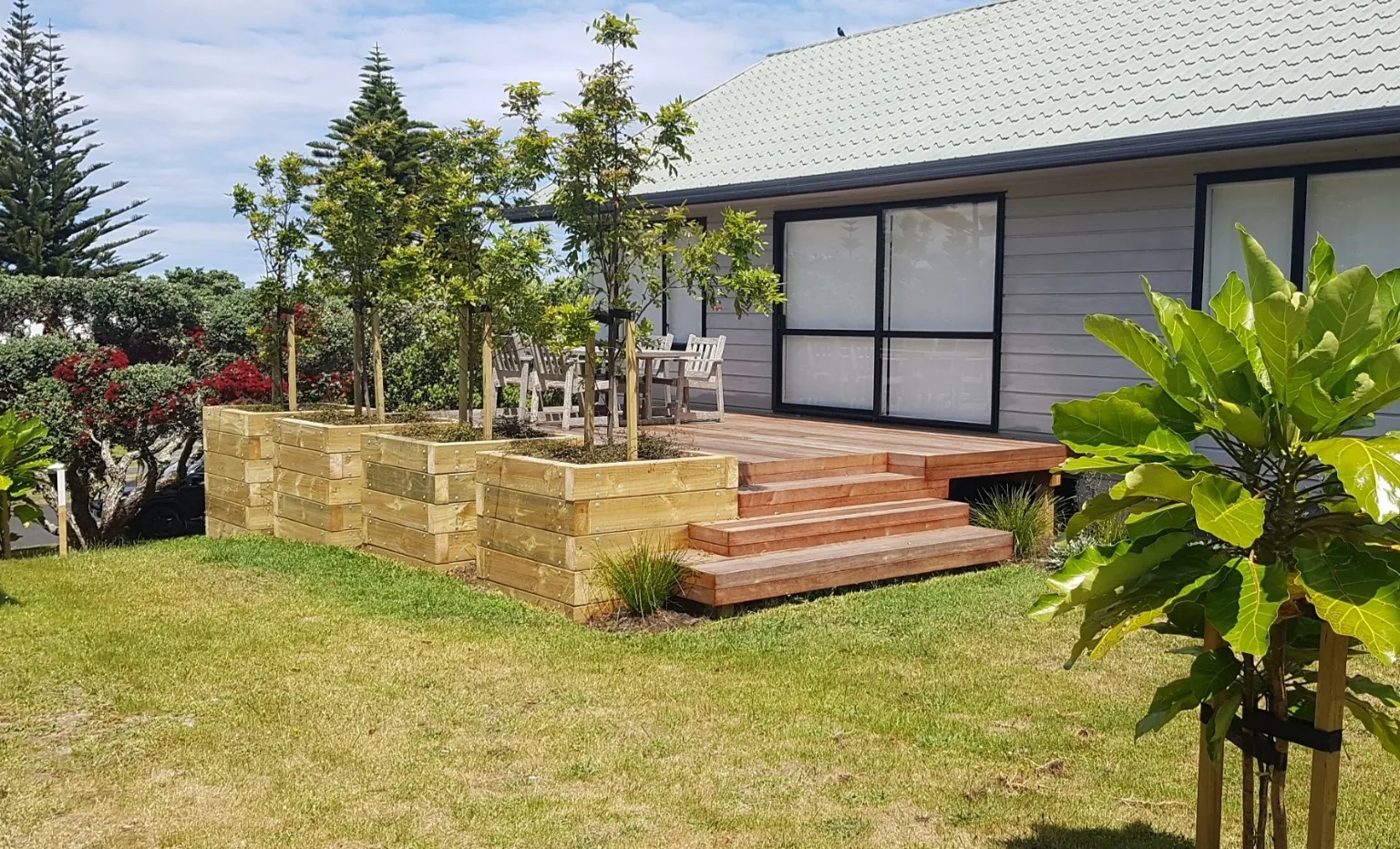 Completed hardwood deck with integrated timber planter boxes and feature steps