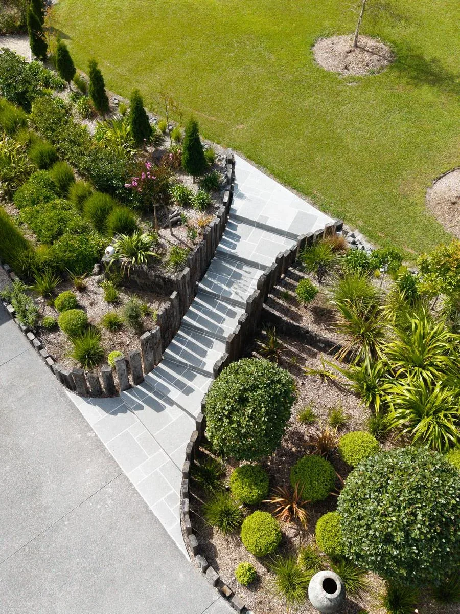 Natural stone steps and pathway with timber retaining walls and integrated planting on an Auckland landscape