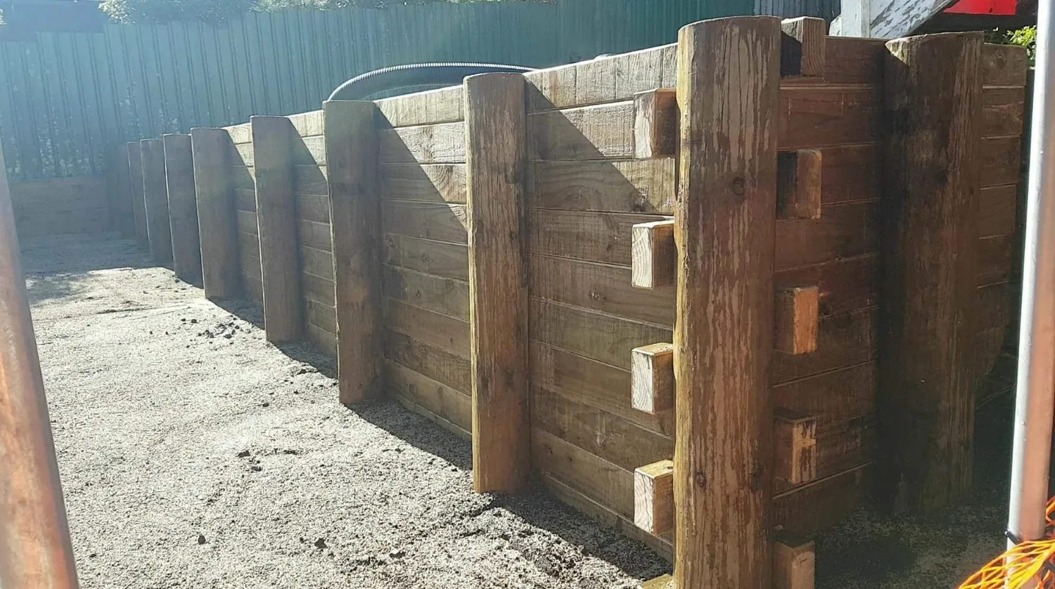 Heavy timber pole-and-rail retaining wall with rebated joinery built by Artizen